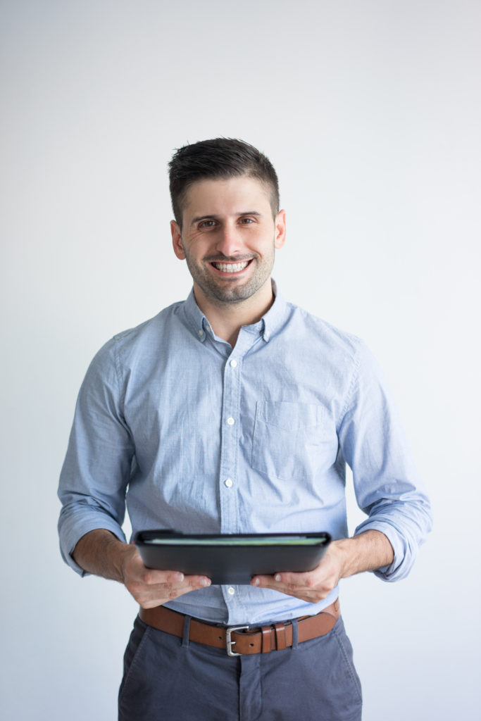 Portrait Of Smiling Businessman Holding Folder With Documents - Objetiva Assessoria
